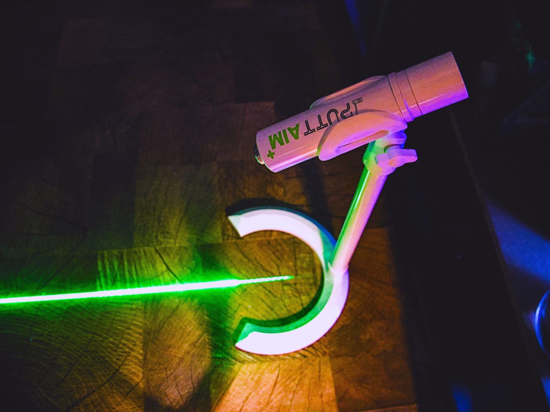 PuttAIM+ golf laser powered on with wood floor -- Techigar