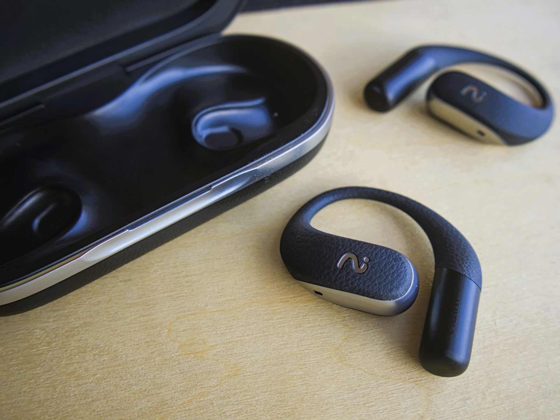 Viaim OpenNote Open Ear earbuds with case on light wood -- Techigar