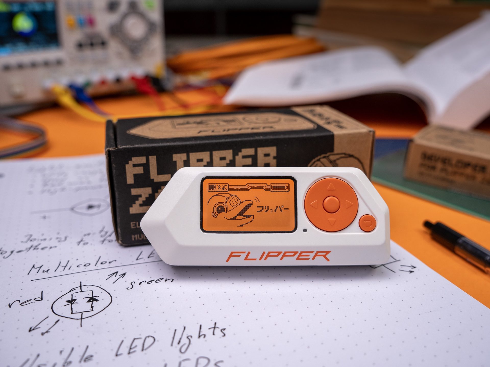 Flipper Zero on desk with electronics and tinkering gear nearby